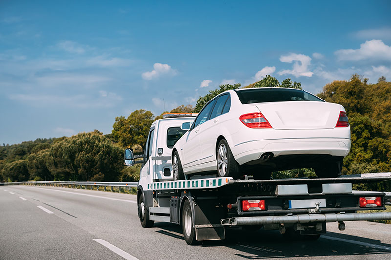 flatbed tow truck transporting car in brockton, MA